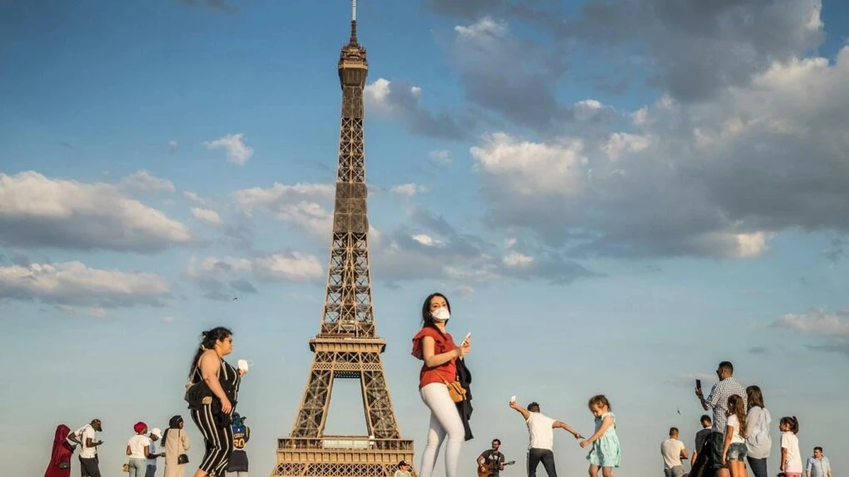 Du khách đi bộ ngay dưới chân tháp Eiffel. Ảnh:Reuters