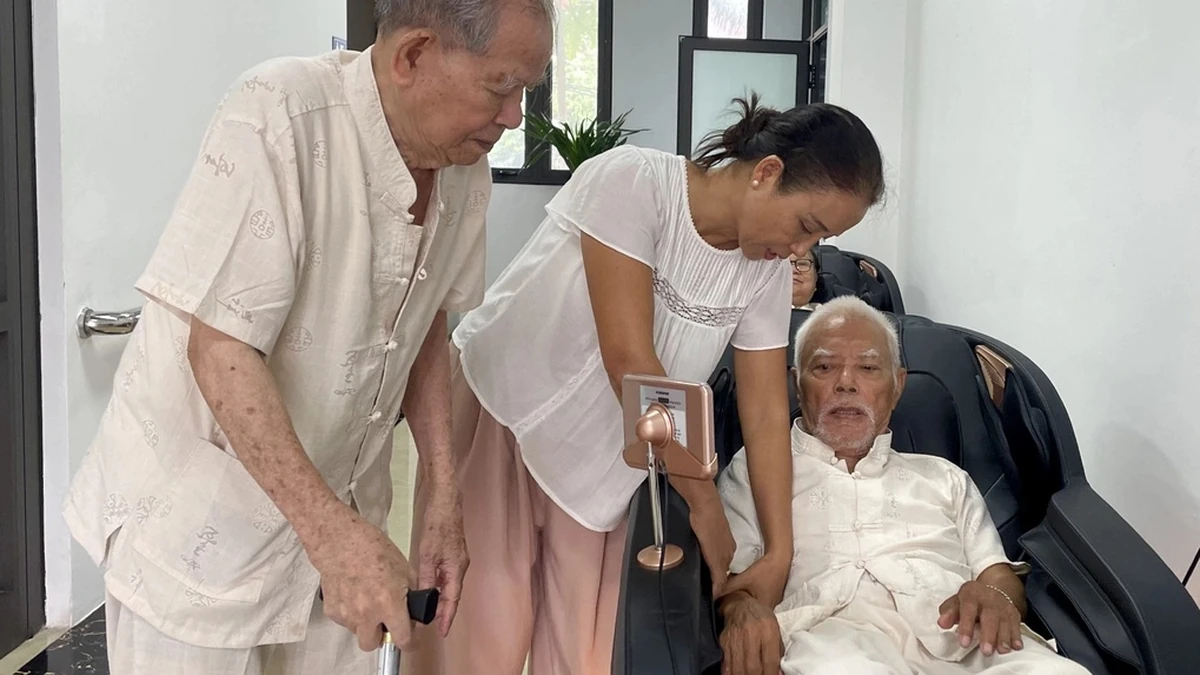 Chị Mai Hương hỗ trợ bố nằm máy massage tại Cơ sở chăm sóc người cao tuổi phường Tây Hồ, hôm 1/10. Ảnh:Phan Dương