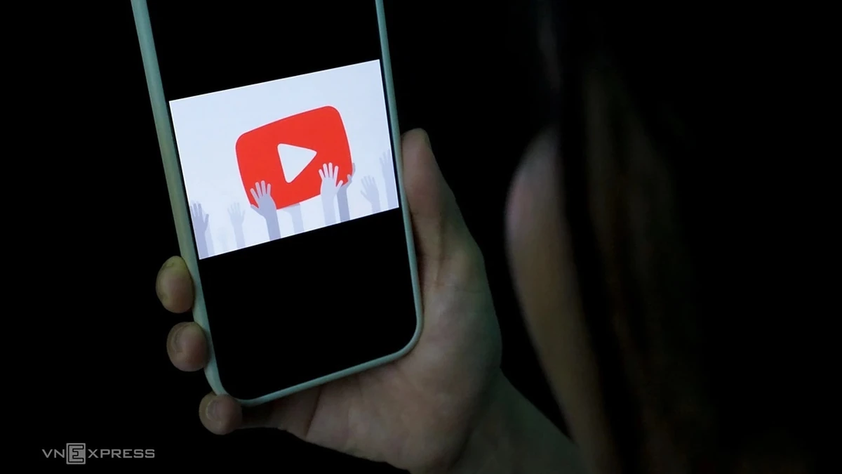Một người sử dụng smartphone với logo YouTube. Ảnh:Bảo Lâm